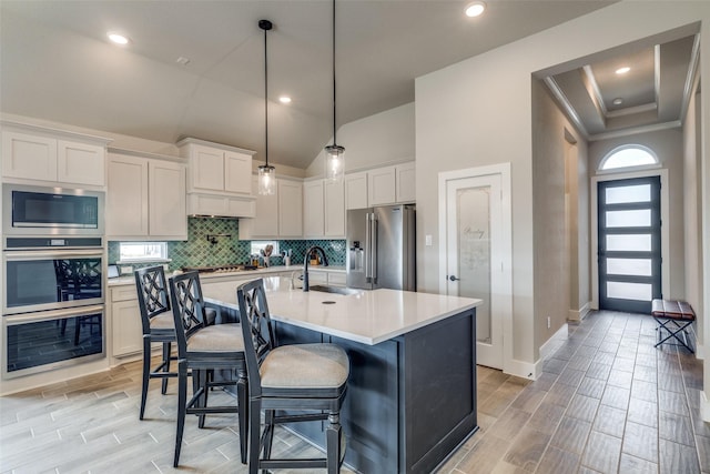 kitchen with light countertops, wood finish floors, stainless steel appliances, and a sink