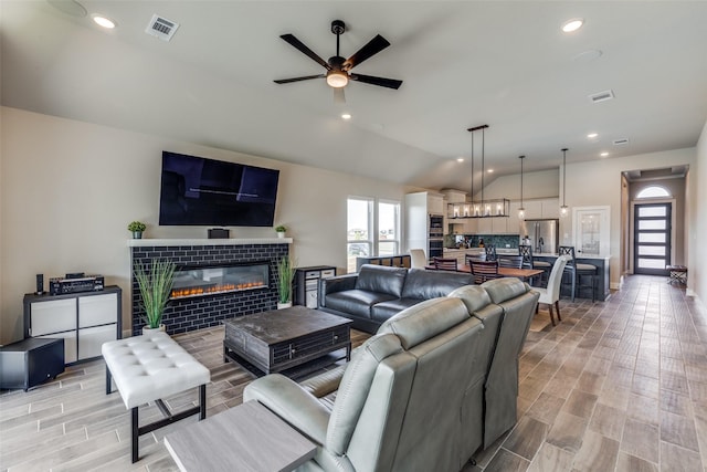 2308 Flock Dr, Mansfield, TX 76063 - living area with ceiling fan, lofted ceiling, a tile fireplace, wood finish floors, and baseboards