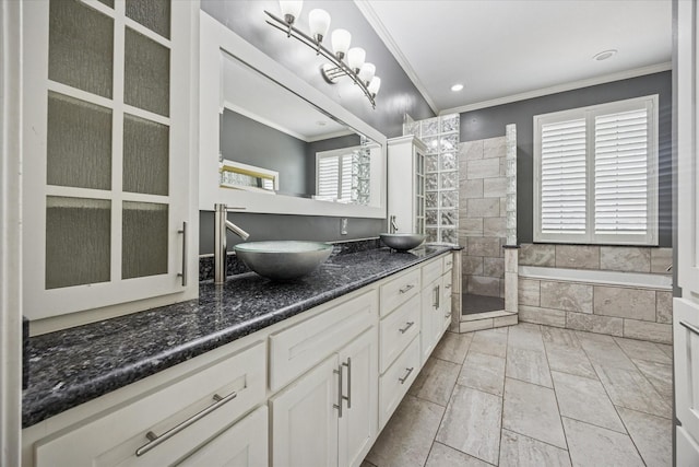 845 Canyon Crest Dr, Irving, TX 75063 - bathroom featuring double vanity, crown molding, a relaxing tiled tub, and a sink