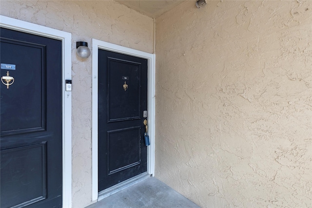 entrance to property featuring stucco siding