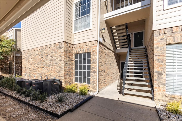doorway to property featuring central air condition unit and brick siding
