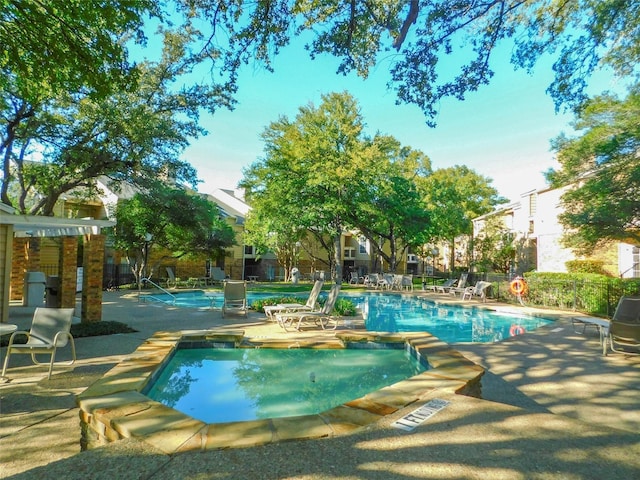 community pool featuring fence and a patio