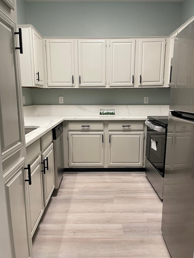 kitchen featuring light stone countertops, dishwasher, light wood-style floors, and electric range