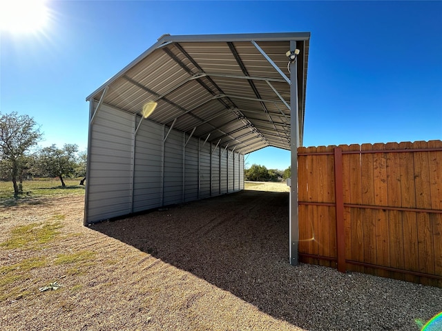 view of outbuilding with fence and a detached carport