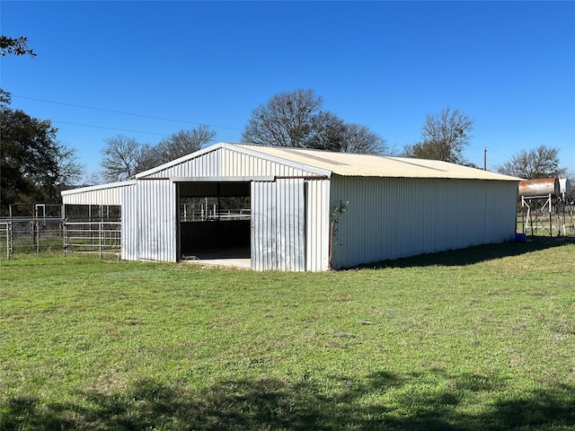 view of pole building with a lawn and fence
