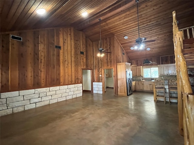 interior space with vaulted ceiling, wood walls, wood ceiling, and finished concrete floors