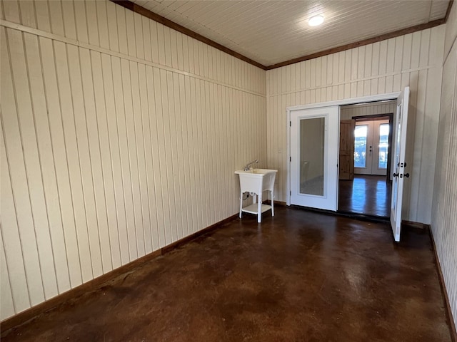 empty room with french doors, a sink, and finished concrete flooring