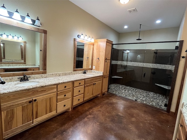 bathroom with a sink, finished concrete flooring, double vanity, and a stall shower