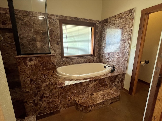 bathroom featuring tile patterned floors, a garden tub, and a tile shower