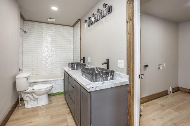 1754 County Road 427, Muenster, TX 76252 - full bath with tiled shower / bath, wood finished floors, toilet, and a sink
