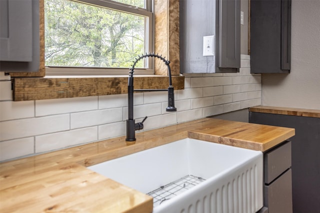1754 County Road 427, Muenster, TX 76252 - details with decorative backsplash, gray cabinetry, a sink, and wooden counters