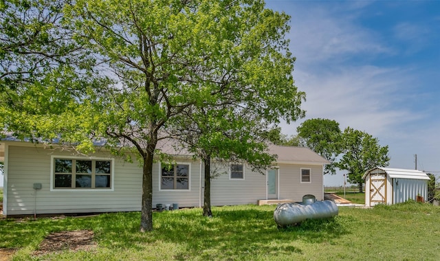 1754 County Road 427, Muenster, TX 76252 - back of house with a storage shed, a lawn, and an outbuilding