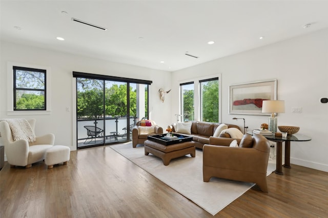 living room with recessed lighting, baseboards, visible vents, and wood finished floors