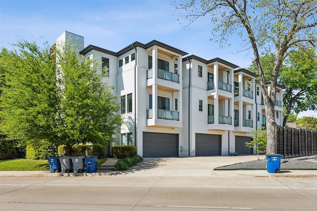 view of building exterior with a garage, fence, and driveway