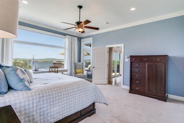 bedroom featuring a water view, baseboards, multiple windows, and light colored carpet