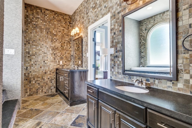 105 Bay Hill Dr, Graford, TX 76449 - bathroom with healthy amount of natural light, tile walls, two vanities, and stone finish flooring