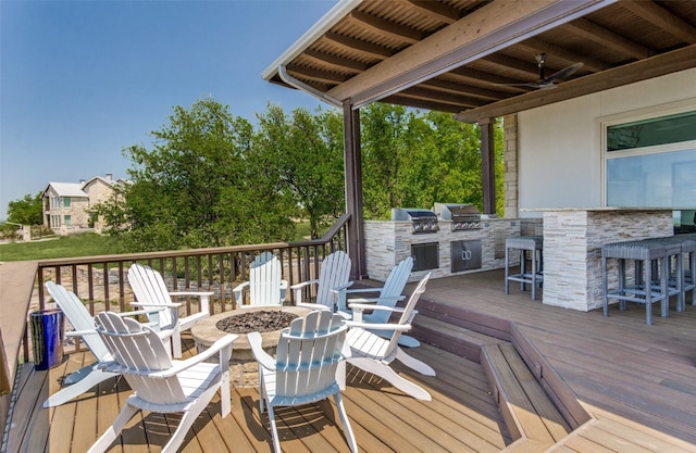 wooden terrace featuring a bar, grilling area, area for grilling, and an outdoor fire pit