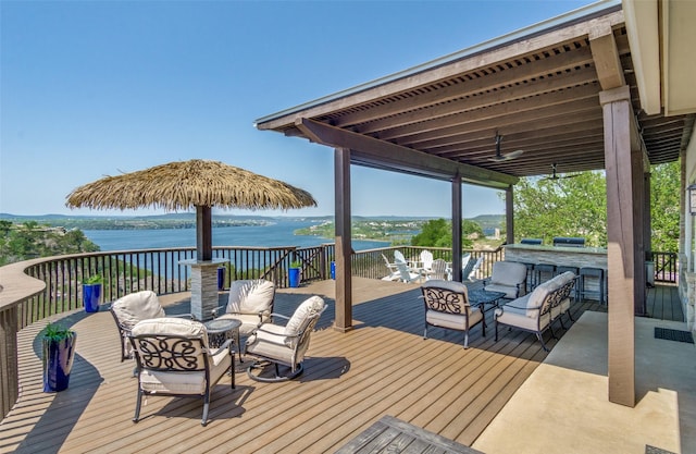 deck featuring outdoor lounge area, area for grilling, and a water view