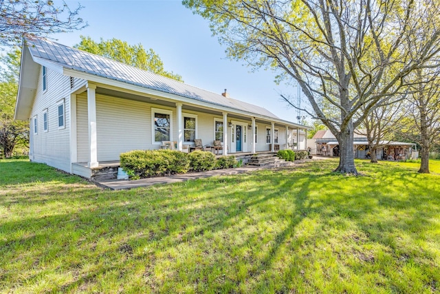 1182 County Road 3025, Bonham, TX 75418 - view of front of property featuring a porch, a front yard, and metal roof