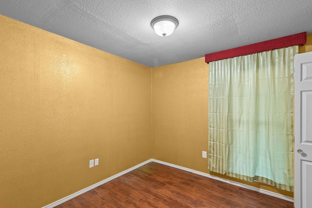 5663 Bretwood Dr, Keithville, LA 71047 - empty room featuring wood finished floors, a textured ceiling, and baseboards