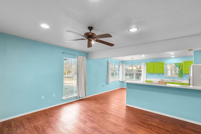 5663 Bretwood Dr, Keithville, LA 71047 - unfurnished living room with recessed lighting, wood finished floors, baseboards, a textured ceiling, and ceiling fan with notable chandelier