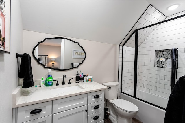bathroom featuring vaulted ceiling, bath / shower combo with glass door, toilet, and vanity
