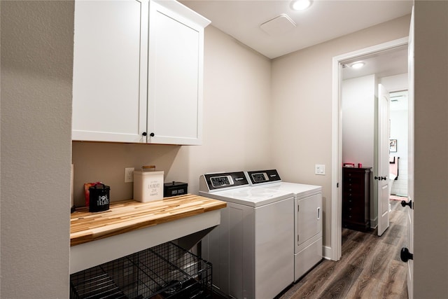 laundry room with separate washer and dryer, wood finished floors, and cabinet space
