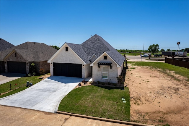 view of front of home with a garage, concrete driveway, fence, a front yard, and brick siding