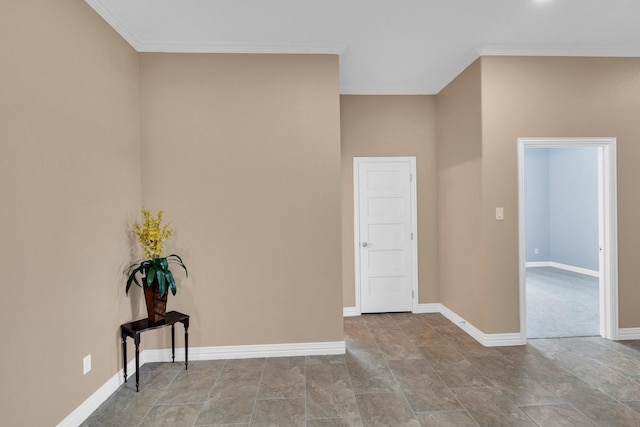 spare room featuring baseboards and crown molding