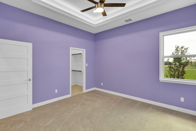 unfurnished bedroom featuring a ceiling fan, a raised ceiling, baseboards, carpet flooring, and visible vents