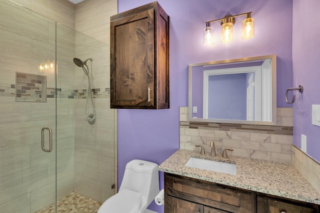 bathroom with toilet, vanity, tasteful backsplash, and a stall shower
