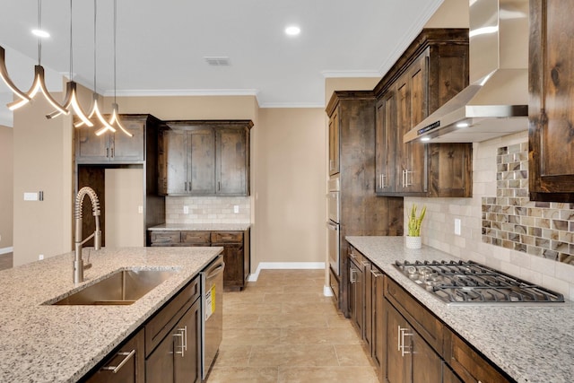 kitchen with wall chimney range hood, a sink, light stone countertops, baseboards, and appliances with stainless steel finishes