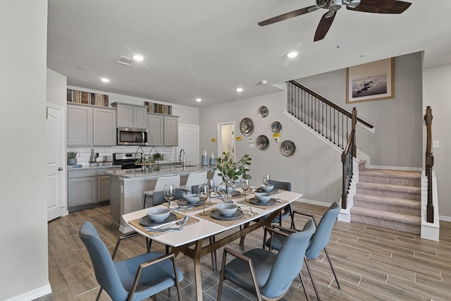 dining room with stairway, baseboards, a ceiling fan, and wood tiled floor