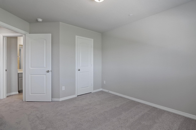 unfurnished bedroom with light carpet and baseboards