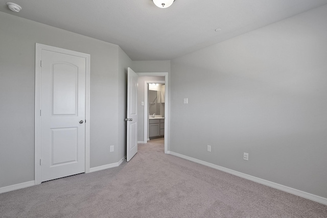 unfurnished bedroom with light carpet and baseboards