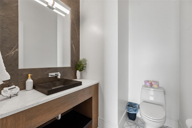 1124 Paradise Cv, Streetman, TX 75859 - bathroom featuring baseboards, toilet, vanity, and tasteful backsplash