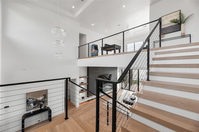 1124 Paradise Cv, Streetman, TX 75859 - stairway featuring a towering ceiling, wood finished floors, and recessed lighting