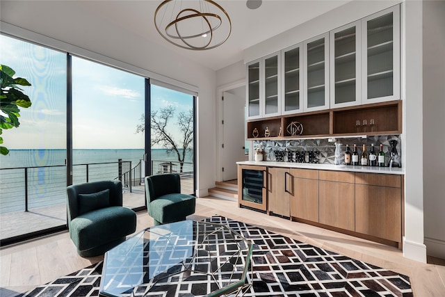 1124 Paradise Cv, Streetman, TX 75859 - bar with decorative backsplash, a water view, an inviting chandelier, indoor bar, and wine cooler