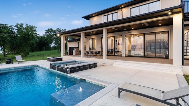 1124 Paradise Cv, Streetman, TX 75859 - back of property with stucco siding, fence, a patio area, and a pool with connected hot tub