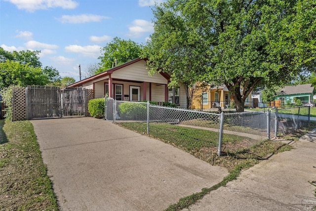 view of front of property with a gate, driveway, a porch, and a fenced front yard