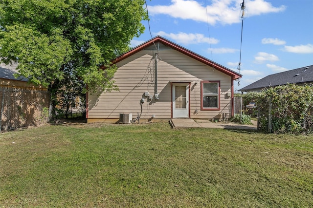 back of property featuring a yard, central AC, a patio, and fence