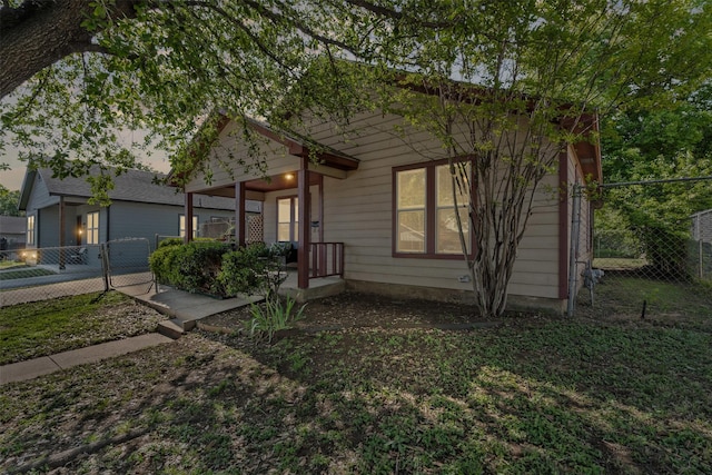 view of front of property featuring a gate, covered porch, and fence