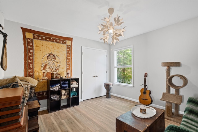 living room with baseboards, wood finished floors, and a chandelier