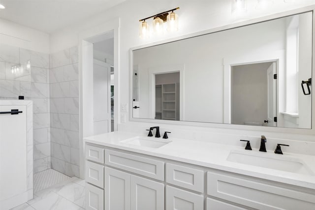 bathroom featuring marble finish floor, walk in shower, a sink, and double vanity