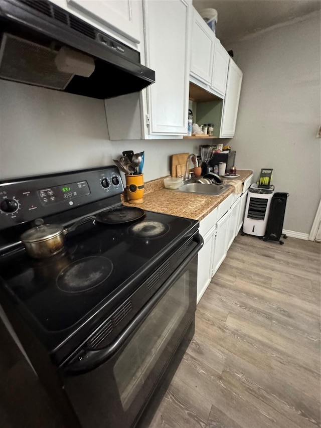 704 N Tennessee St, Mckinney, TX 75069 - kitchen featuring white cabinets, under cabinet range hood, a sink, light wood-type flooring, and electric range