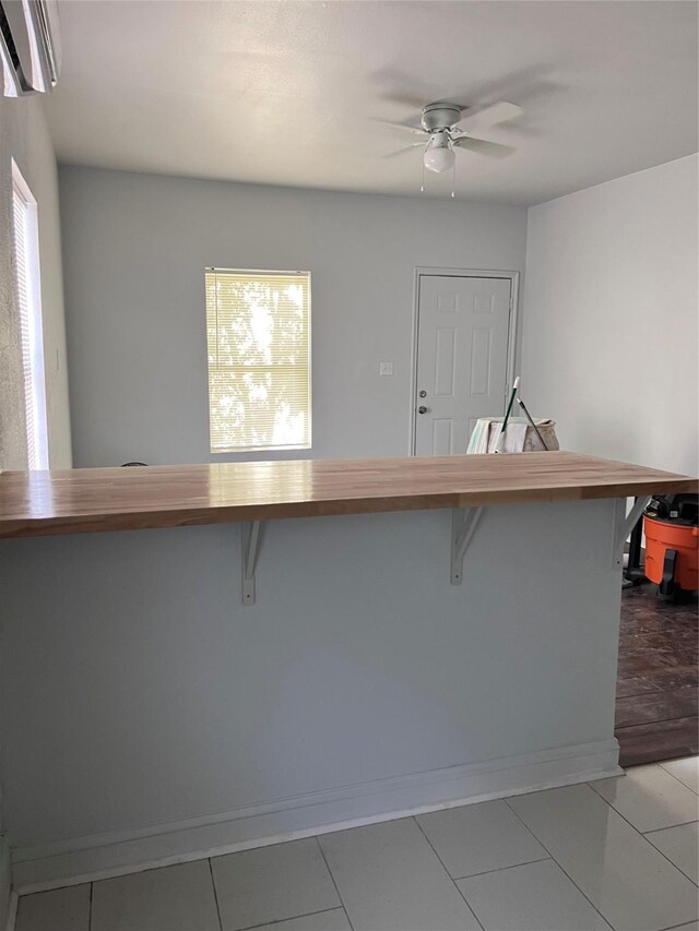 708 N Tennessee St, Mckinney, TX 75069 - kitchen featuring ceiling fan, a kitchen bar, an AC wall unit, and wooden counters