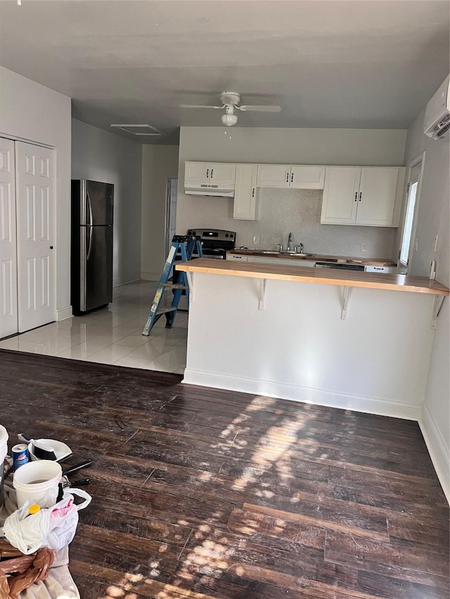 708 N Tennessee St, Mckinney, TX 75069 - kitchen with freestanding refrigerator, a breakfast bar area, a peninsula, white cabinetry, and a sink