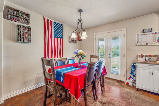 dining space with french doors, baseboards, a textured ceiling, and finished concrete flooring