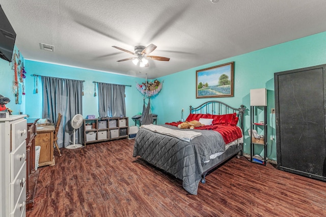 bedroom featuring a textured ceiling, wood finished floors, visible vents, and ceiling fan
