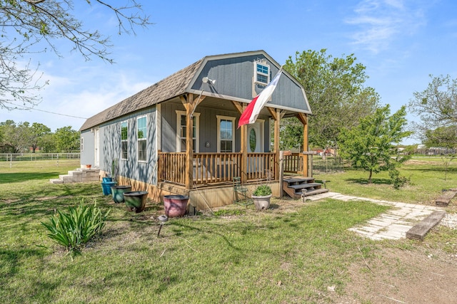 exterior space featuring a yard, a gambrel roof, covered porch, and fence